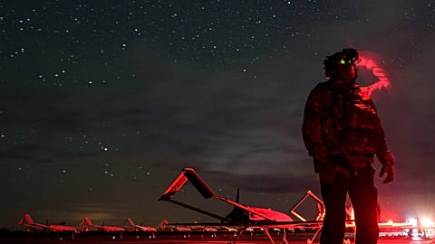 A Ukrainian soldier looks through night vision goggles before An-196 Liutyi long-range drones take off towards Russia; Ukraine, 14 October 2025