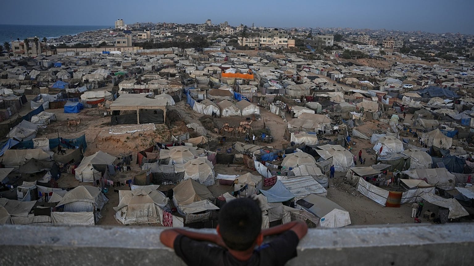 طفل ينظر إلى مخيم مؤقت للنازحين الفلسطينيين في غزة السبت 1 نوفمبر 2025