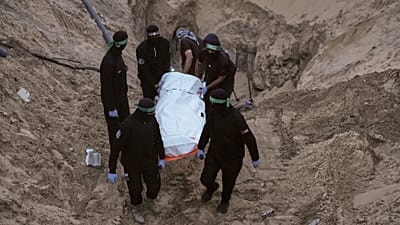 شبه‌نظامیان حماس کیسه سفیدی را حمل می‌کنند که گمان می‌رود حاوی جسد یکی از گروگان‌ها باشد