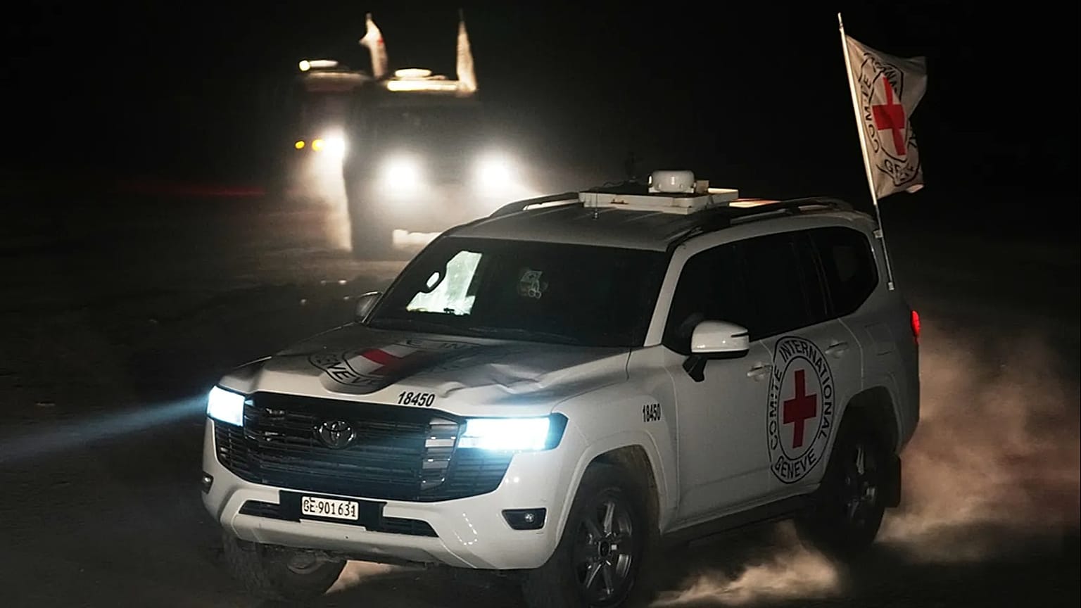 Red Cross vehicles carrying the bodies of three people believed to be deceased hostages handed over by Hamas make their way toward the border crossing with Israel