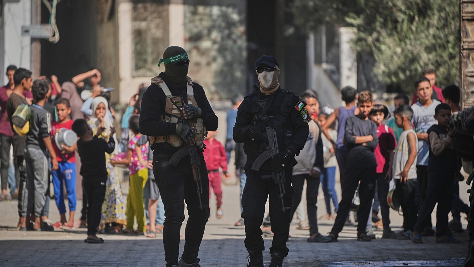 A Hamász milicistái őrködnek, miközben elrabolt izraeli túszok maradványait keresik egyiptomi munkások a Gázai övezetben lévő Nuszeiratban 2025. október 28-án 