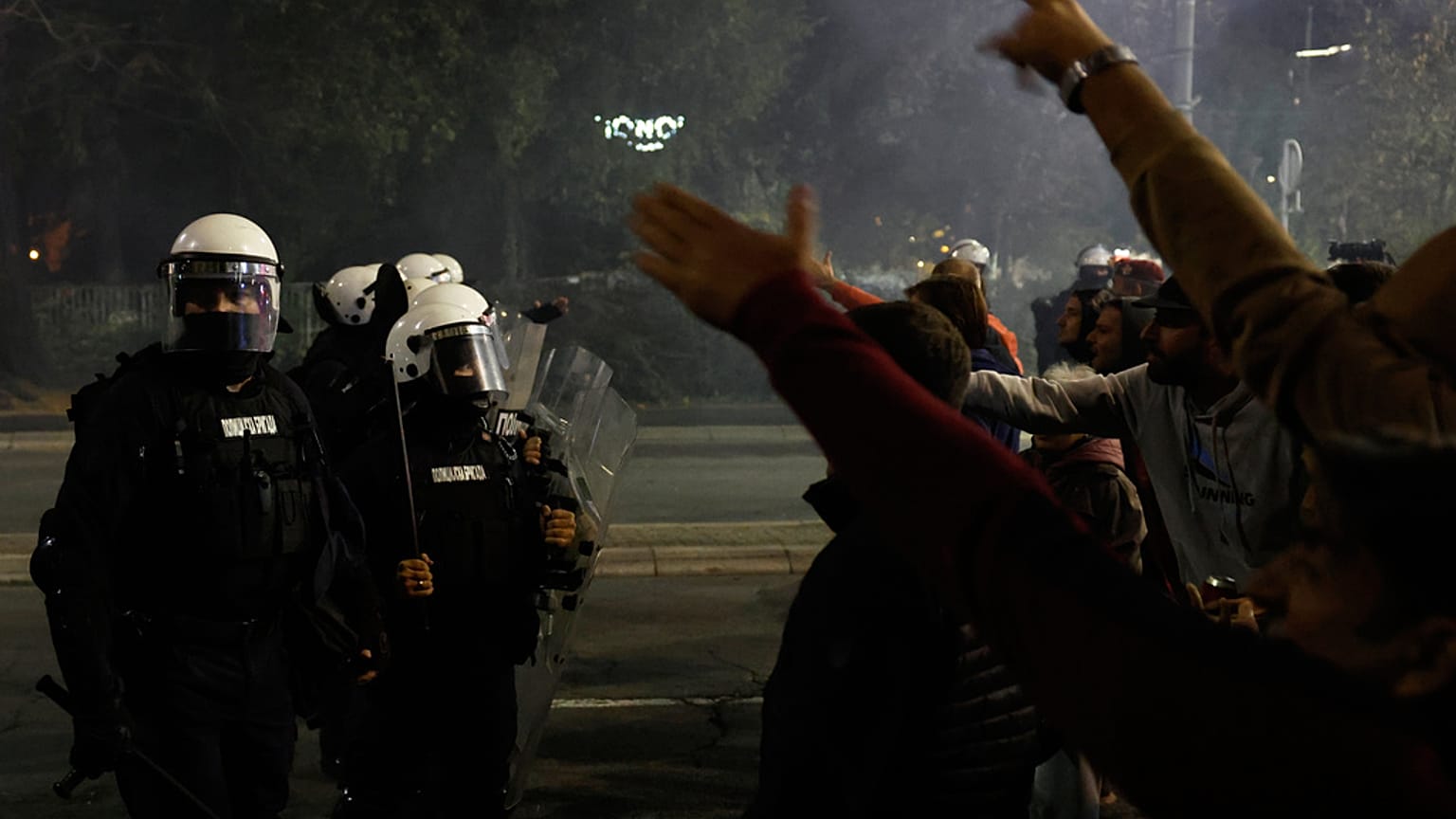 Polícia de choque sérvia separa multidões rivais de opositores, à direita, e partidários do presidente autocrático Aleksandar Vucic