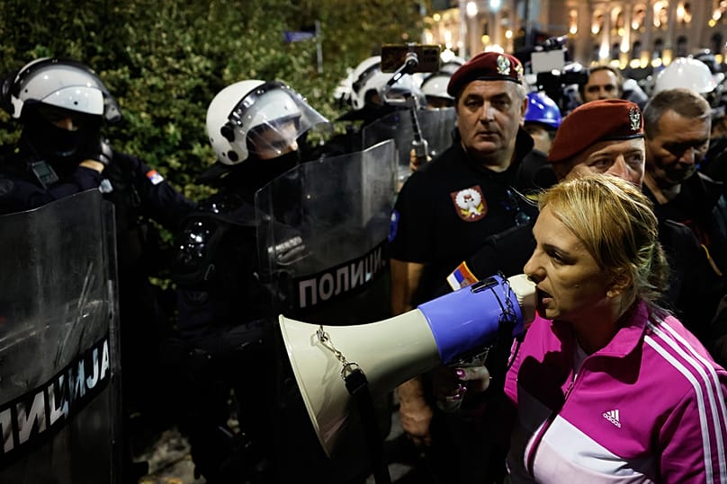 Dijana Hrka, mãe de uma das 16 vítimas da tragédia ocorrida numa estação ferroviária no norte da Sérvia há um ano, discursa durante o protesto