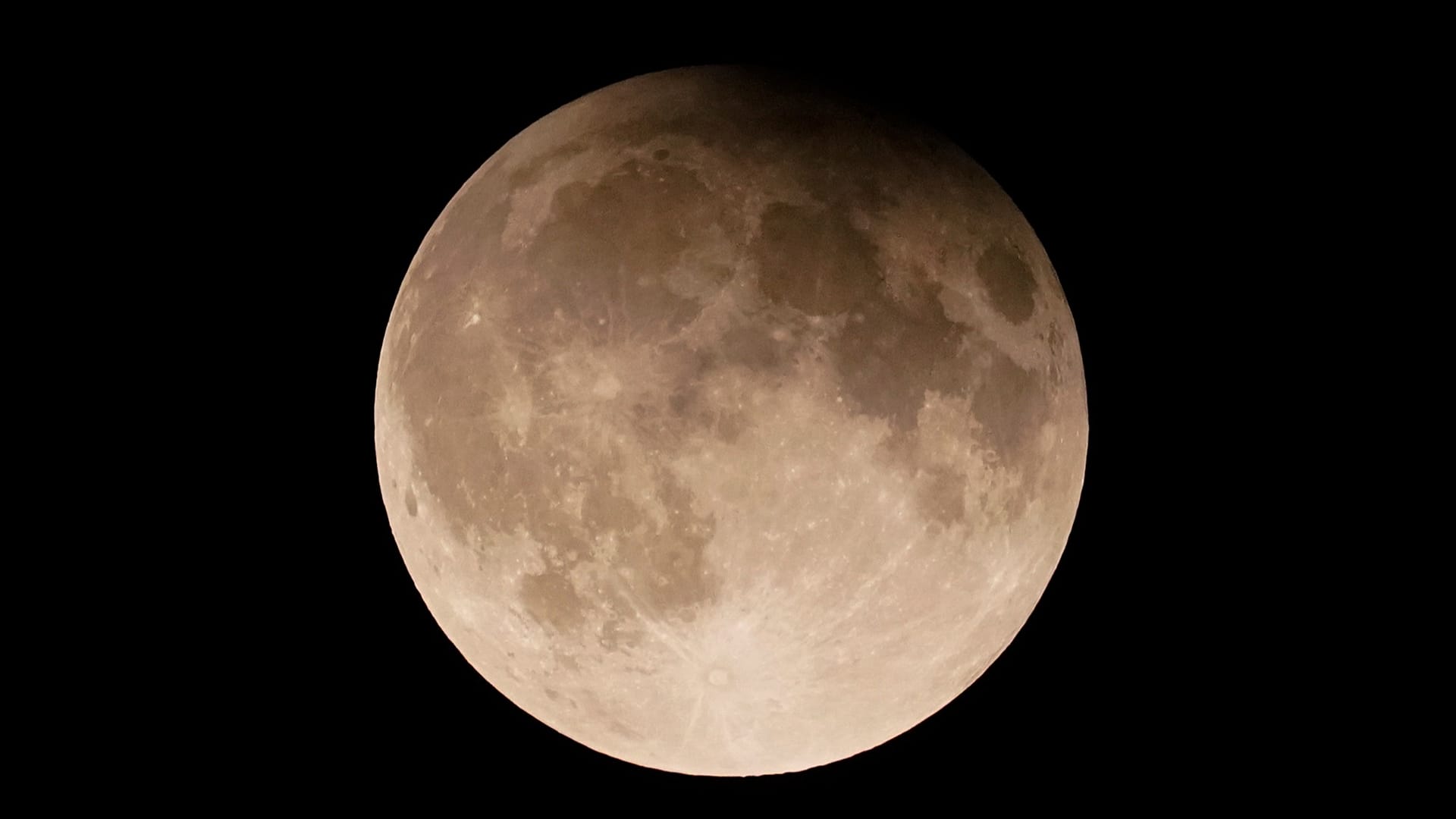 Une super Lune, accompagnée d'une éclipse lunaire partielle, se lève au-dessus du lac Michigan, à Chicago, le 17 septembre 2024.