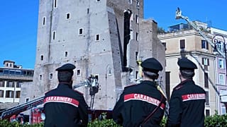 Italian Carabinieri look as firefighters work to rescue a construction worker from under the debris of the partially collapsed medieval Torre de Conti in Rome, 3 November 2025