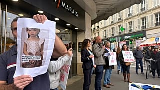 A protester holds a picture of a childlike sex doll outside BHV Marais department store in Paris, where Shein is due to open its first permanent physical store world wide.