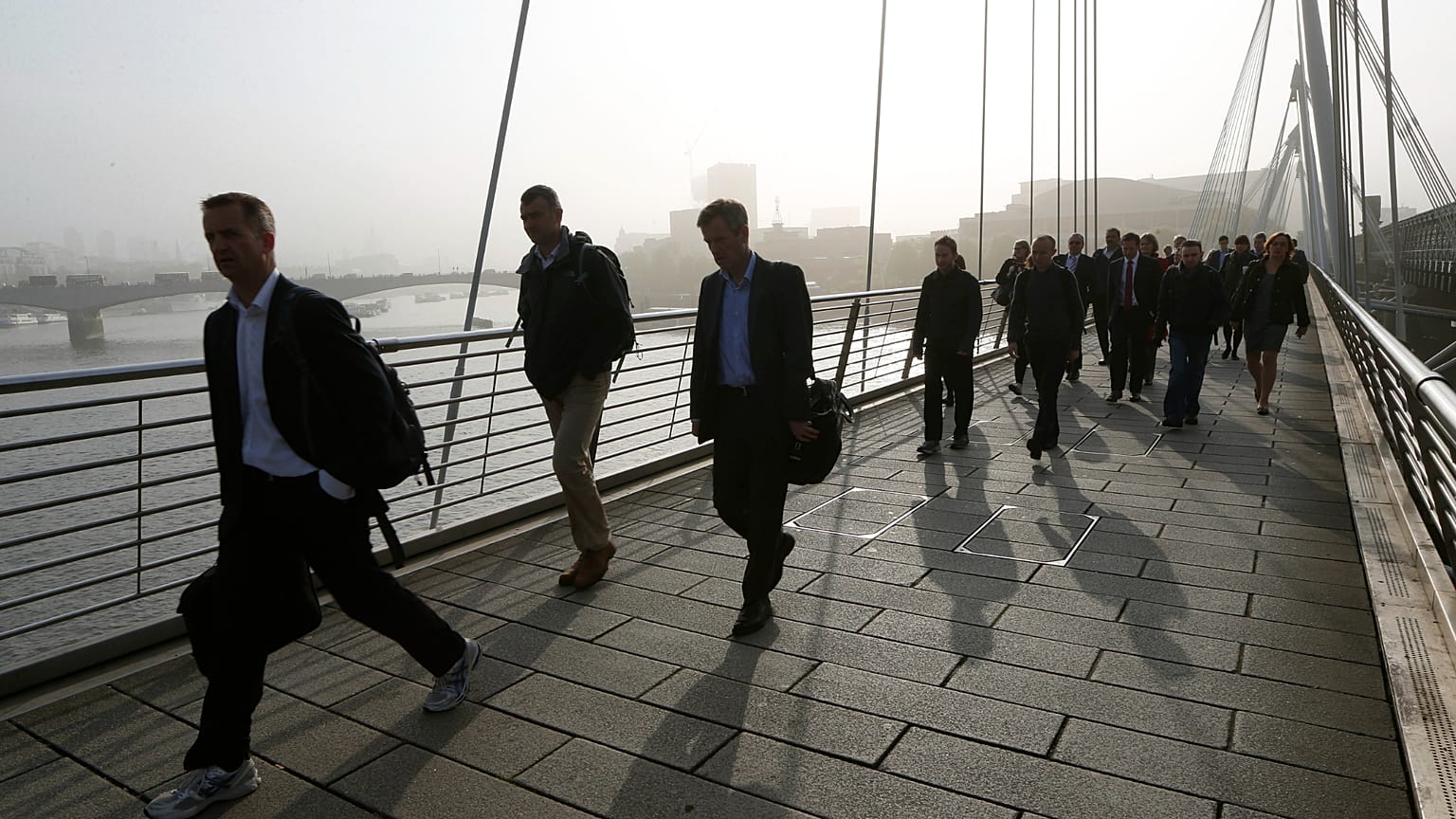 People walk across Hungerford pedestrain bridge in London. 30 April 2014.