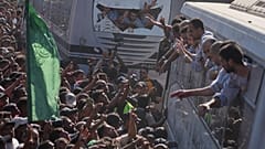 يتجمع الناس لاستقبال السجناء الفلسطينيين المحررين الواصلين في الحافلات إلى قطاع غزة بعد إطلاق سراحهم من السجون الإسرائيلية، قطاع غزة، يوم الاثنين 13 أكتوبر/تشرين الأول 2025. 