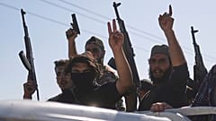 مقاتلون بدو يقفون على شاحنة صغيرة عند وصولهم إلى قرية الدور على مشارف مدينة السويداء ، خلال اشتباكات بين العشائر البدوية والميليشيات الدرزية ، جنوب سوريا ، الجمعة 18 تموز 2025