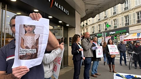 Un manifestant tient la photo d'une poupée sexuelle enfantine devant le grand magasin BHV Marais à Paris, lundi 3 novembre 2025.