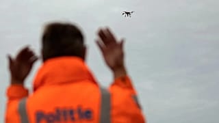 A police officer directs a truck as a drone flies overhead at a scanning area at the Port of Zeebrugge, 9 September, 2019