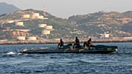 FILE: Navy sailors ride atop a 10-metre submarine packed with more than 5 tonnes of cocaine, as it is being towed into the port of Salina Cruz, Mexico, 18 July 2008