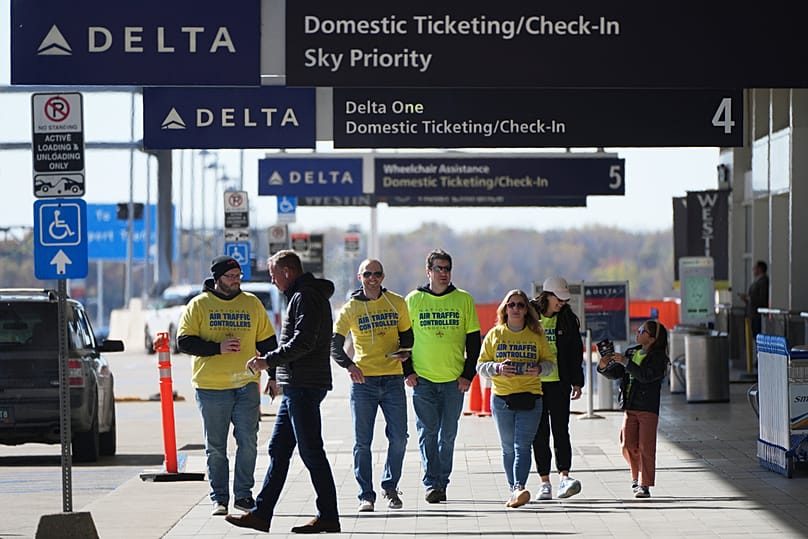 Air Traffic Controllers distribute leaflets explaining how the federal government shutdown is impacting air travel at Detroit Metropolitan Wayne County Airport 