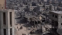 فلسطينيون يسيرون وسط الدمار الذي خلّفته الحرب في مدينة خان يونس، جنوبي قطاع غزة، يوم الاثنين 8 نيسان/أبريل 2024