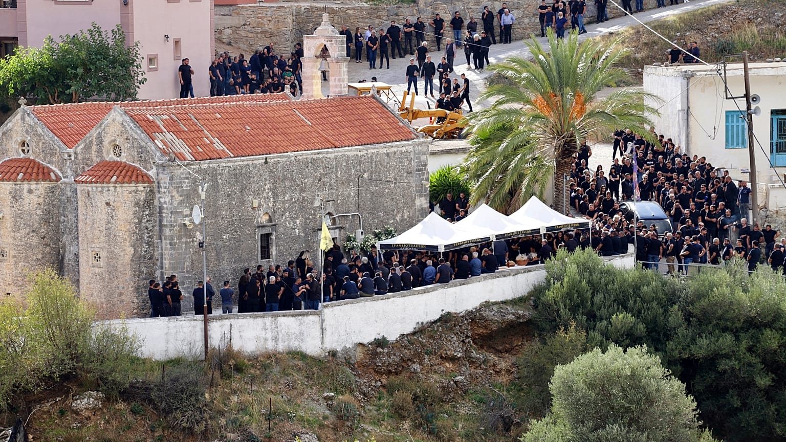 Συγγενείς, φίλοι και κάτοικοι σχηματίζουν πομπή πίσω από τη νεκροφόρα που μεταφέρει τη σορό στην κηδεία του 39χρονου άνδρα στα Βορίζια