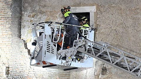 Des pompiers extirpent un ouvrier du bâtiment des décombres d'une tour médiévale, en rénovation près du Forum romain, à Rome,