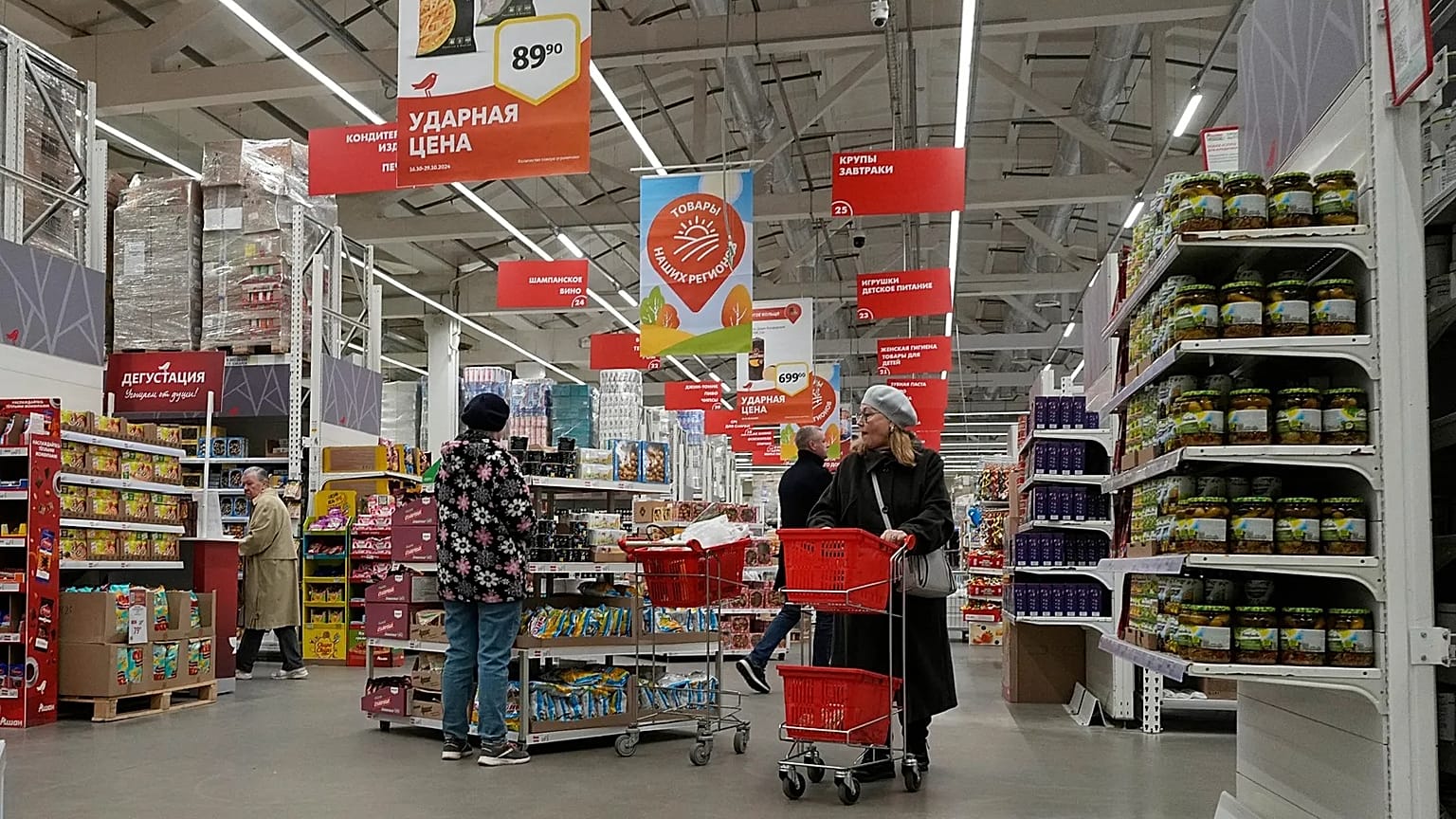 Customers choose food products in a store of the French retailer Auchan in St. Petersburg, 24 October, 2024
