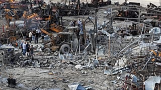 لبنانيون يتفقدون الموقع الذي استهدفته غارات إسرائيلية ليل الأربعاء، وأصابت جرافات في بلدة أنصارية جنوب لبنان، الخميس 4 أيلول 2025.