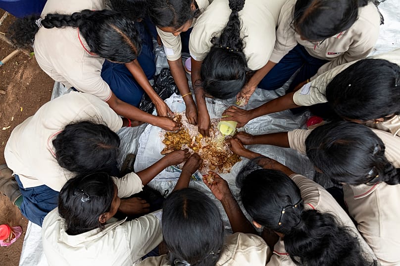 A team of women deminers in Sri Lanka sharing a meal together during their lunch break.