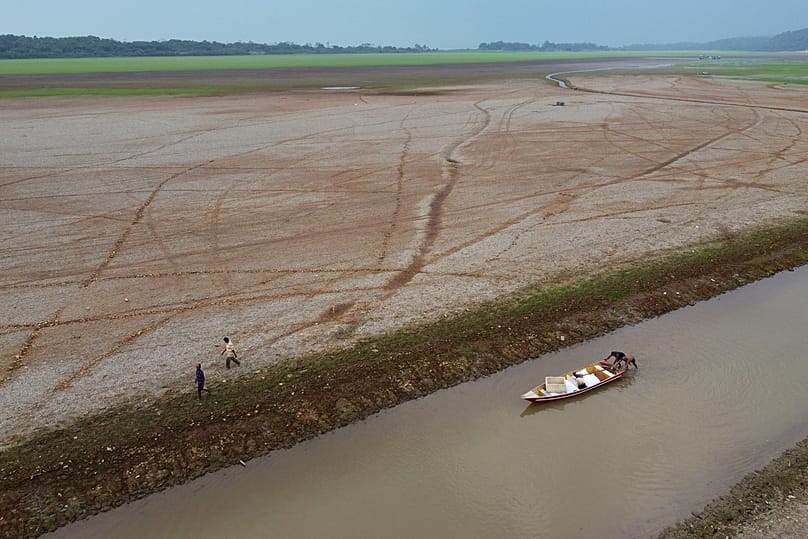 Des pêcheurs poussent un bateau sur le lac Aleixo en pleine sécheresse à Manaus, dans l'État d'Amazonas, au Brésil, le 24 septembre 2024