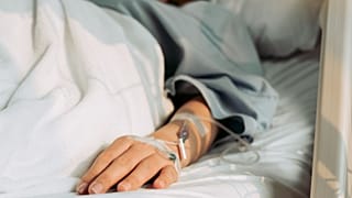 A hospital patient lies in bed.
