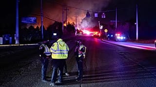 Members of law enforcement wear respirators near the area of the reported plane crash at Louisville Muhammad Ali International Airport, in Louisville, KY, 4 November 2025