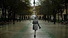 Una mujer camina por el vacío paseo marítimo Sarasate mientras cae la lluvia, en Pamplona, ​​norte de España, el 16 de marzo de 2020.