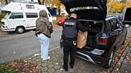 Police officers carry seized material from an apartment in the Mümmelmannsberg district after a raid in Hamburg, 5 November, 2025