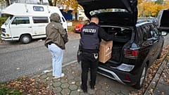 Police officers carry seized material from an apartment in the Mümmelmannsberg district after a raid in Hamburg, 5 November, 2025