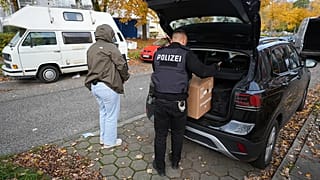 Police officers carry seized material from an apartment in the Mümmelmannsberg district after a raid in Hamburg, 5 November, 2025
