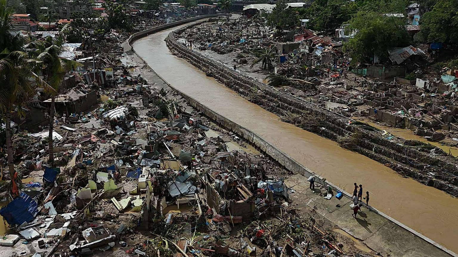 Los vecinos regresan a lo que queda de sus viviendas tras el tifón Kalmaegi, que devastó comunidades a lo largo del río Mananga en la ciudad de Talisay.