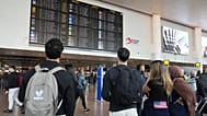 Passengers look at a departure board after several cancellations and delays due to reported overnight drone activity over Brussels International Airport, 5 November, 2025