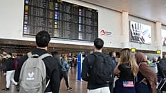Fluggäste sehen sich eine Abflugtafel an, nachdem mehrere Annullierungen und Verspätungen aufgrund von gemeldeten nächtlichen Drohnenaktivitäten über dem internationalen Flughafen Brüssel gemeldet wurden, 5. November 2025