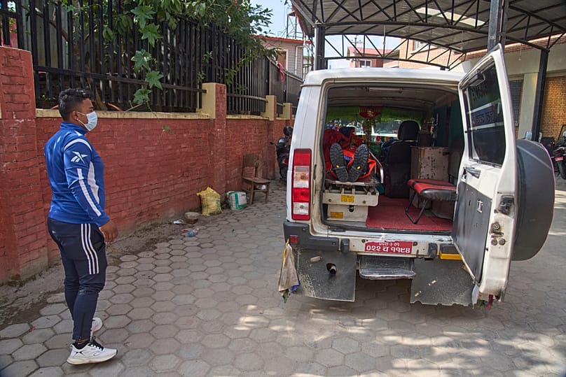Une ambulance transportant le corps d'un alpiniste tué dans une avalanche sur le mont Yalung Ri 