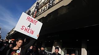 A demonstrator holds a poster reading "Shame on Shein" outside the BHV department store where fast fashion powerhouse Shein's first permanent store opened. Paris. 5 Nov. 2025.