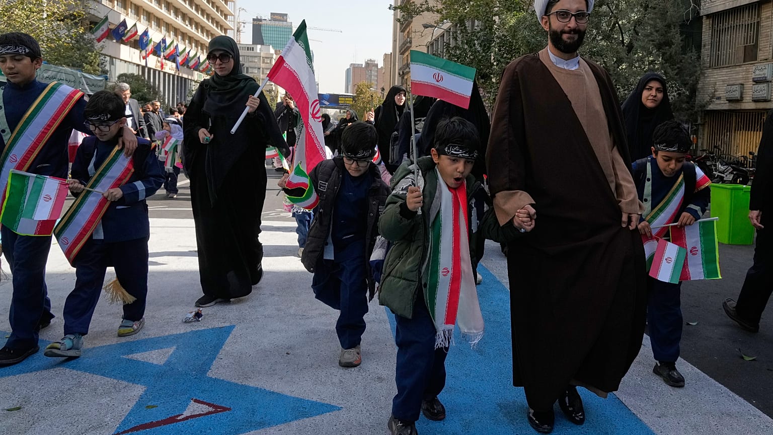 Un religieux, des élèves et d’autres piétinent une image du drapeau israélien, à l’étoile de David ensanglantée, lors d’une manifestation annuelle à l’ex-ambassade américaine