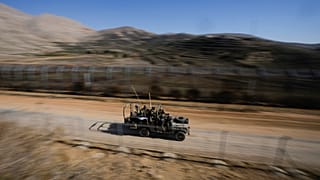 يقف جنود إسرائيليون على مركبة مدرعة بعد عبورهم السياج الأمني على ما يُعرف بخط ألفا الذي يفصل مرتفعات الجولان الخاضعة للسيطرة الإسرائيلية عن سوريا، في بلدة مجدل شمس،