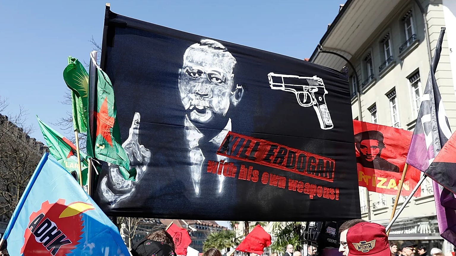 A banner reads; 'Kill Erdoğan with his own weapons' as protesters march during a demonstration against the Turkish president in Bern, 25 March, 2017 