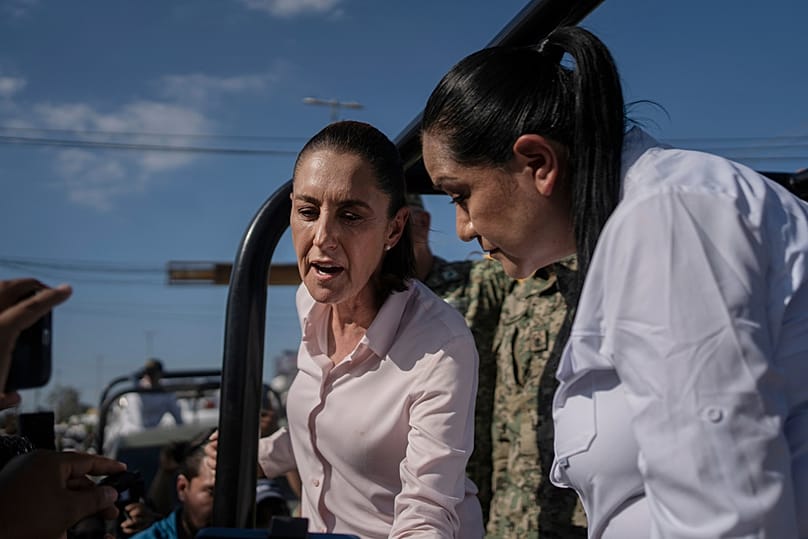 Mexican President Claudia Sheinbaum, left, and Veracruz Gov. Rocío Nahle García survey authorities' aid distribution in Poza Rica, Mexico, Sunday, Oct. 12, 2025