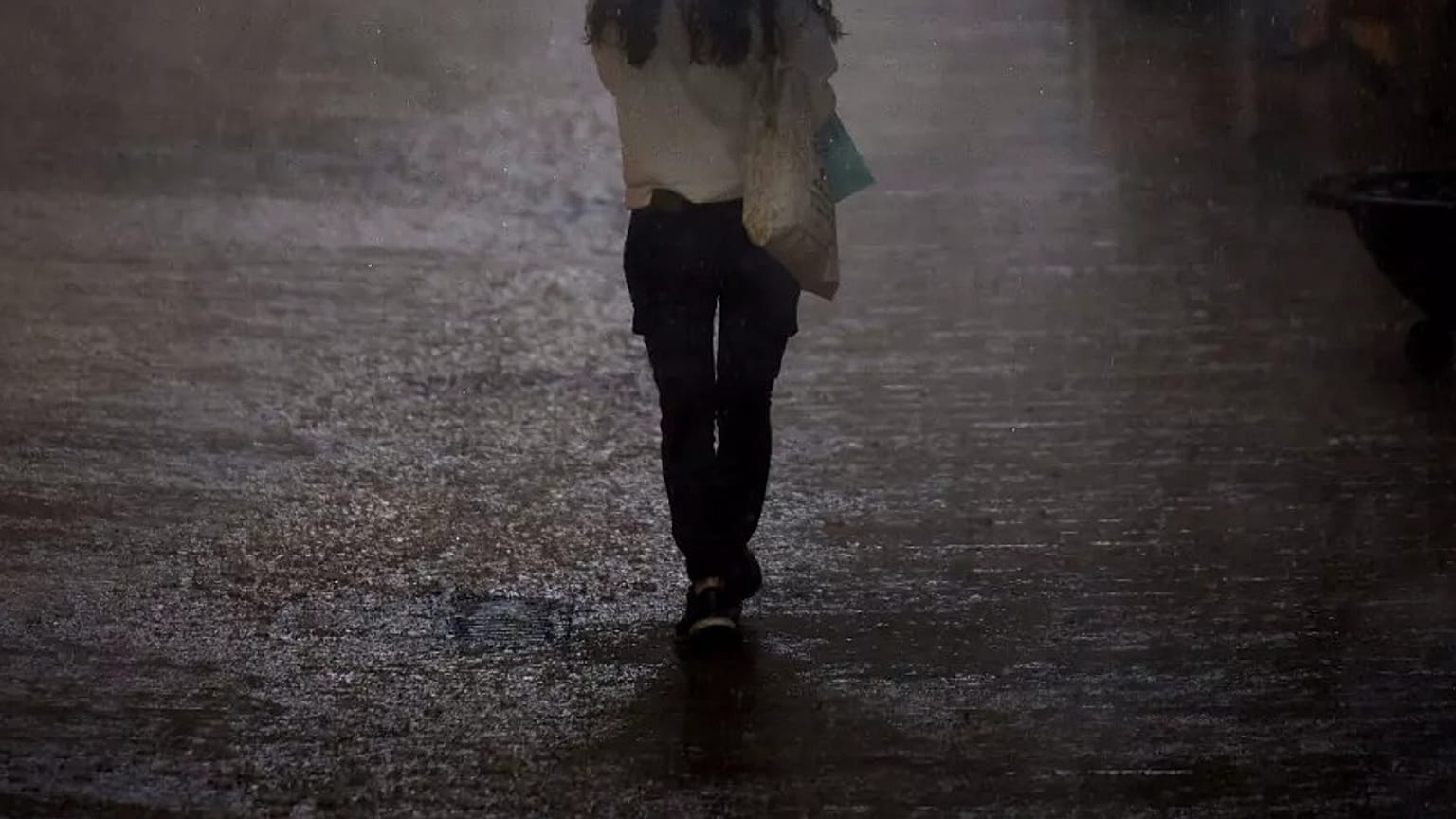 ARCHIVO - Una mujer camina bajo una fuerte lluvia en Barcelona, ​​España, el jueves 11 de septiembre de 2025.