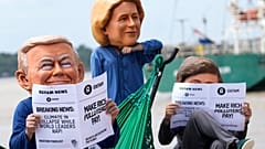 Oxfam-Aktivisten tragen Puppenköpfe in Anlehnung an US-Präsident Donald Trump (links), EU-Kommissionspräsidentin Ursula von der Leyen (Mitte) und den Präsidenten von Arg
