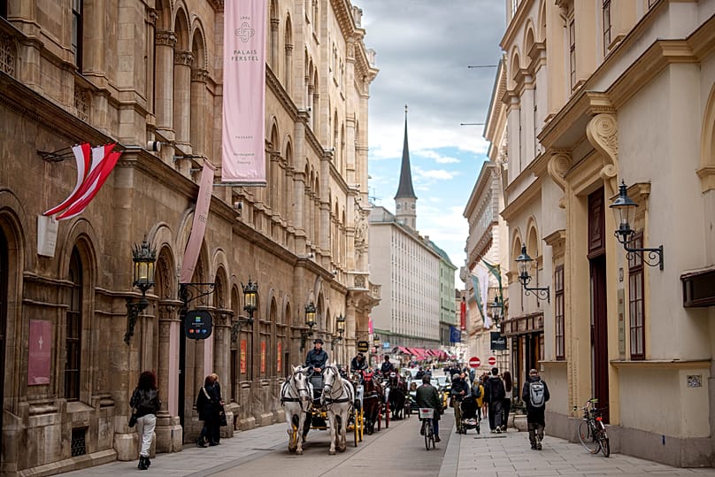 Horse-drawn carriages make their way along a street in Vienna, 28 September, 2024