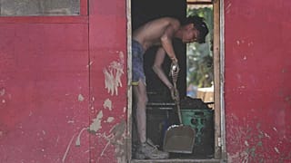 Un hombre limpia una casa dañada por las inundaciones del tifón Kalmaegi, en Liloan, provincia de Cebú, centro de Filipinas, el jueves seis de noviembre de 2025.