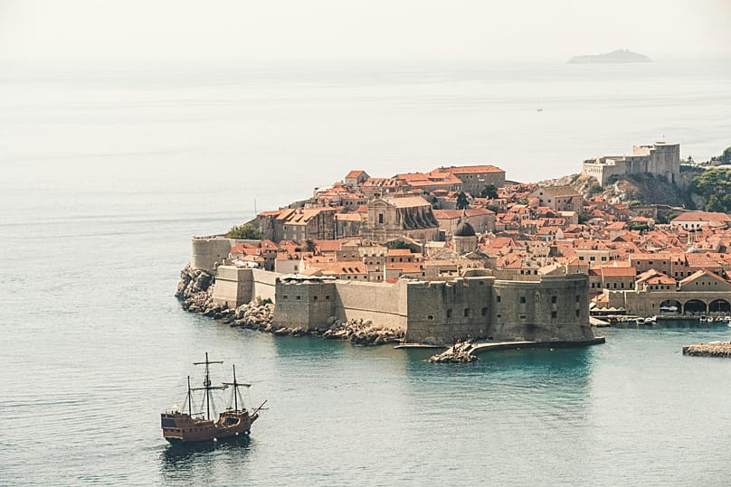 A brown ship sails into Dubrovnik, Croatia. 