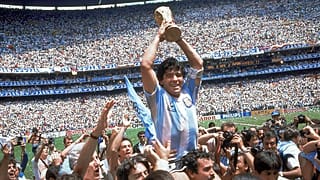 Diego Maradona holds up his team's trophy after Argentina's 3-2 victory over West Germany at the World Cup final match, 29 June 1986