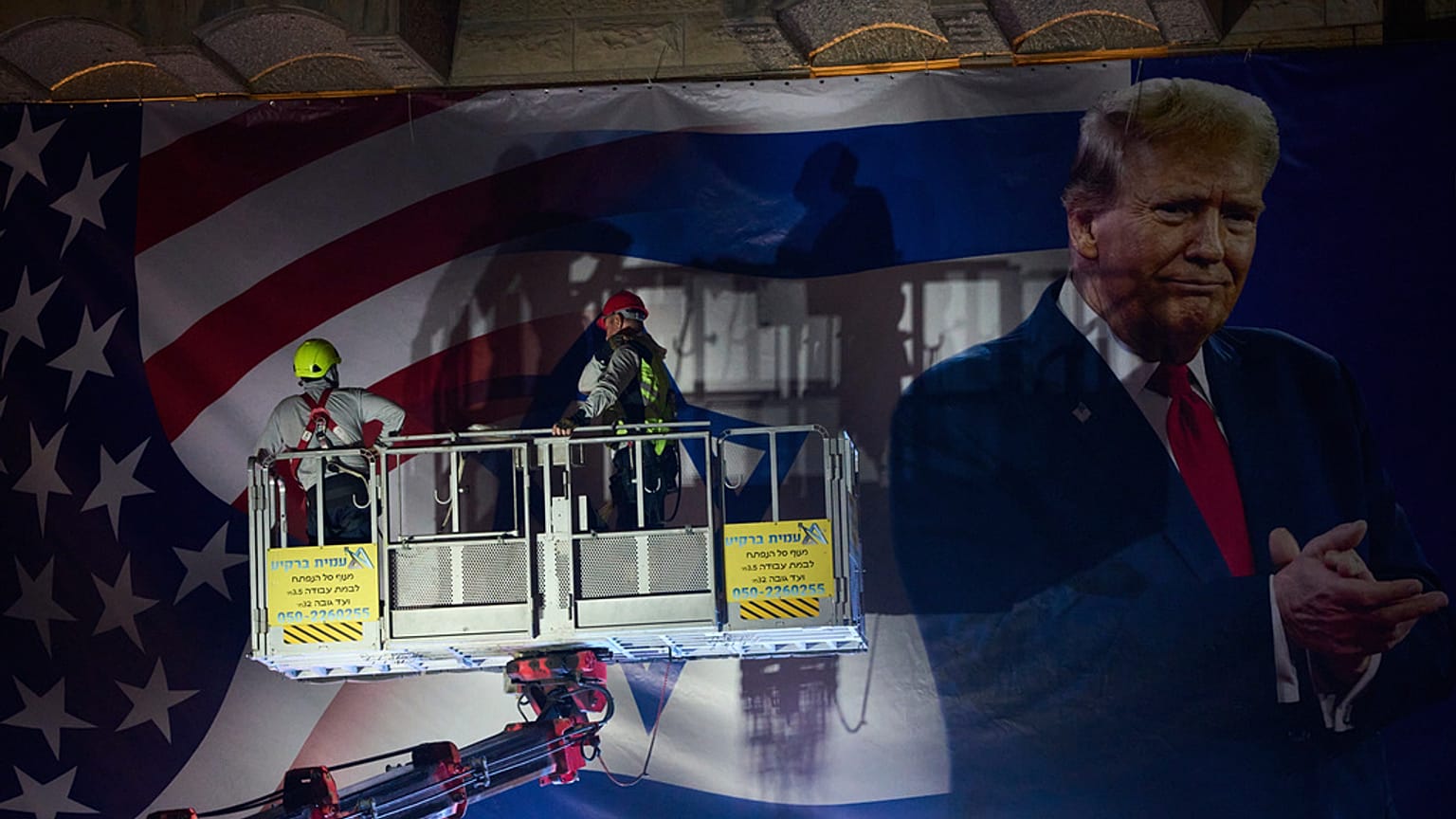 عمال يعلقون لوحة إعلانية كبيرة عليها صورة الرئيس الأمريكي دونالد ترامب في القدس يوم الأحد 12 أكتوبر 2025.