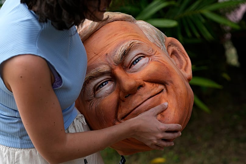 ناشط في منظمة أوكسفام يحمل رأس دمية على هيئة الرئيس الأمريكي دونالد ترامب في احتجاج قبل مؤتمر الأمم المتحدة للمناخ COP30 في بيليم، الأربعاء 5 نوفمبر 2025. 