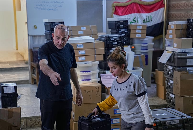 عاملون من المفوضية العليا للانتخابات في العراق يحضّرون للانتخابات البرلمانية داخل مركز اقتراع في بغداد، 6 نوفمبر 2025.