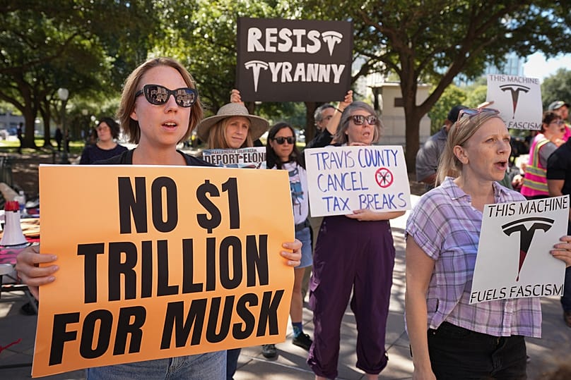People participate in a protest outside the state Capitol in Austin, Texas, on Wednesday, Nov. 5, 2025, against Tesla's proposed $1 trillion pay package for CEO Elon Musk