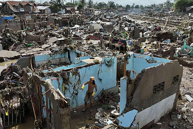 A resident returns to what remains of a home in the aftermath of Typhoon Kalmaegi that devastated communities along the Mananga River in Talisay, Philippines, Nov. 5, 2025